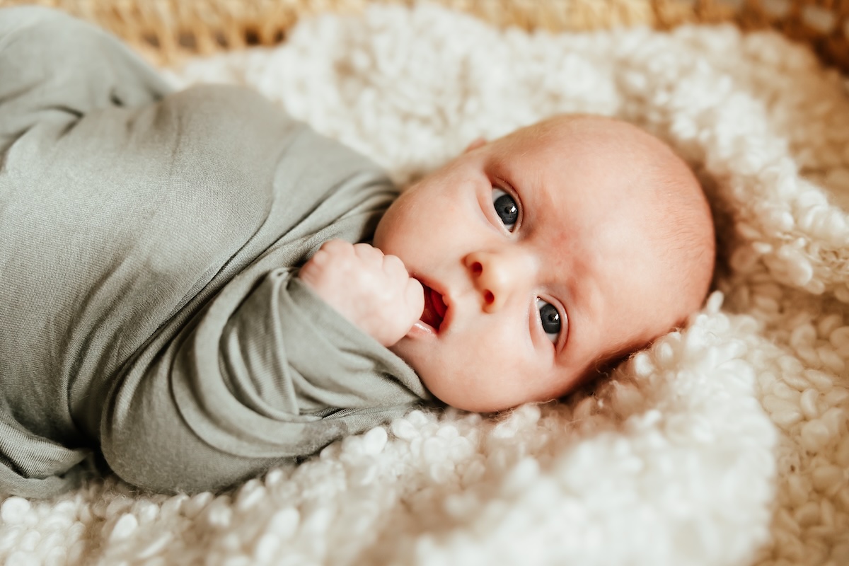 A newborn baby looks at the camera while