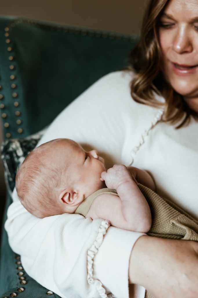 A close up of a mother holding her newborn baby in her arm.
