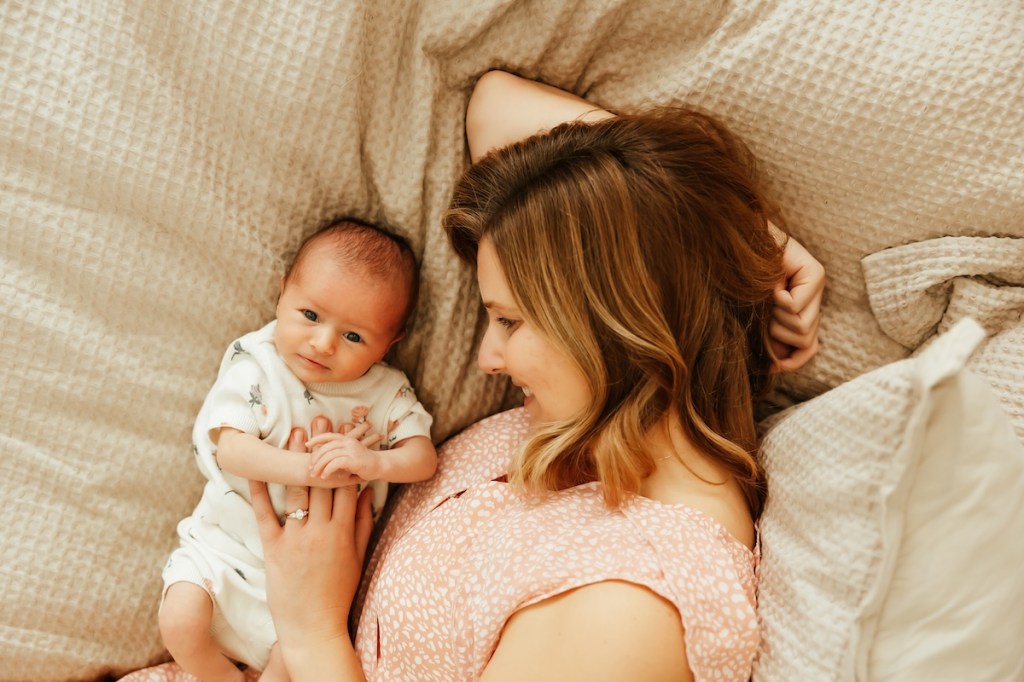 Overhead shot of baby and mother on a bed.