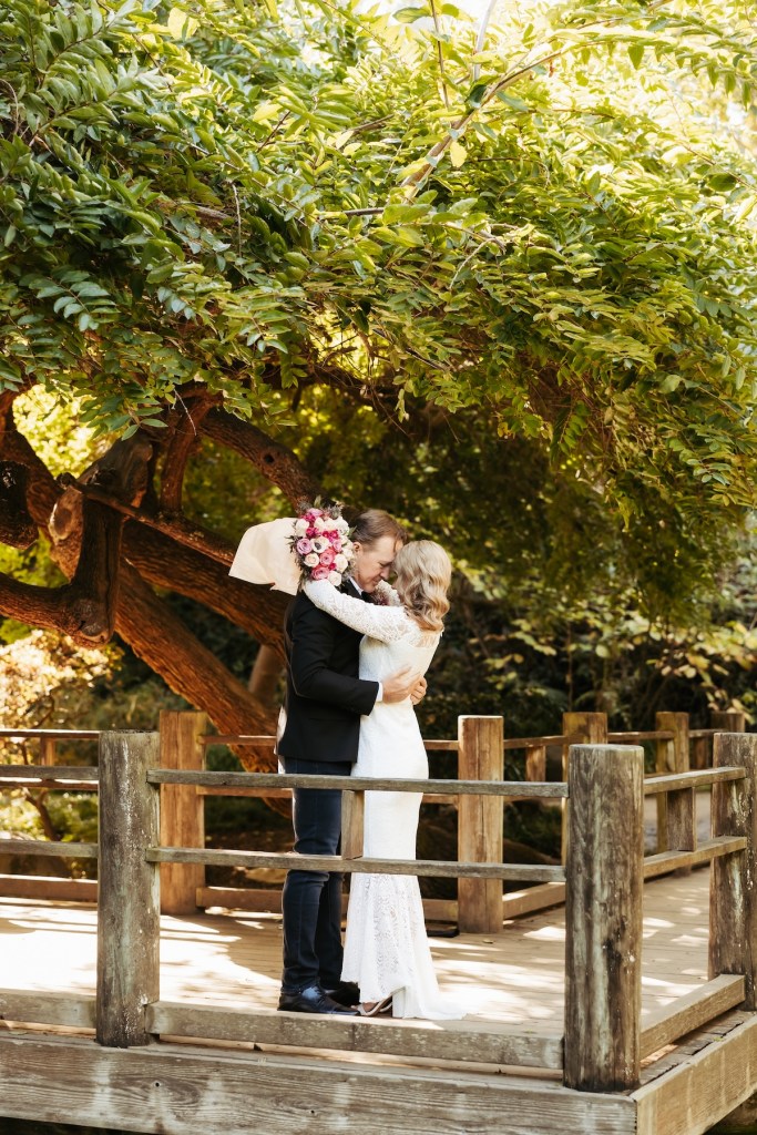 Bride and groom embrace at the Moon Viewing Garden in SF Botanical Garden.