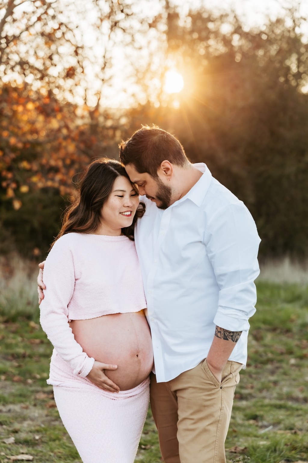 Mother and Father embrace for a maternity photo at golden hour in the Bay Area.