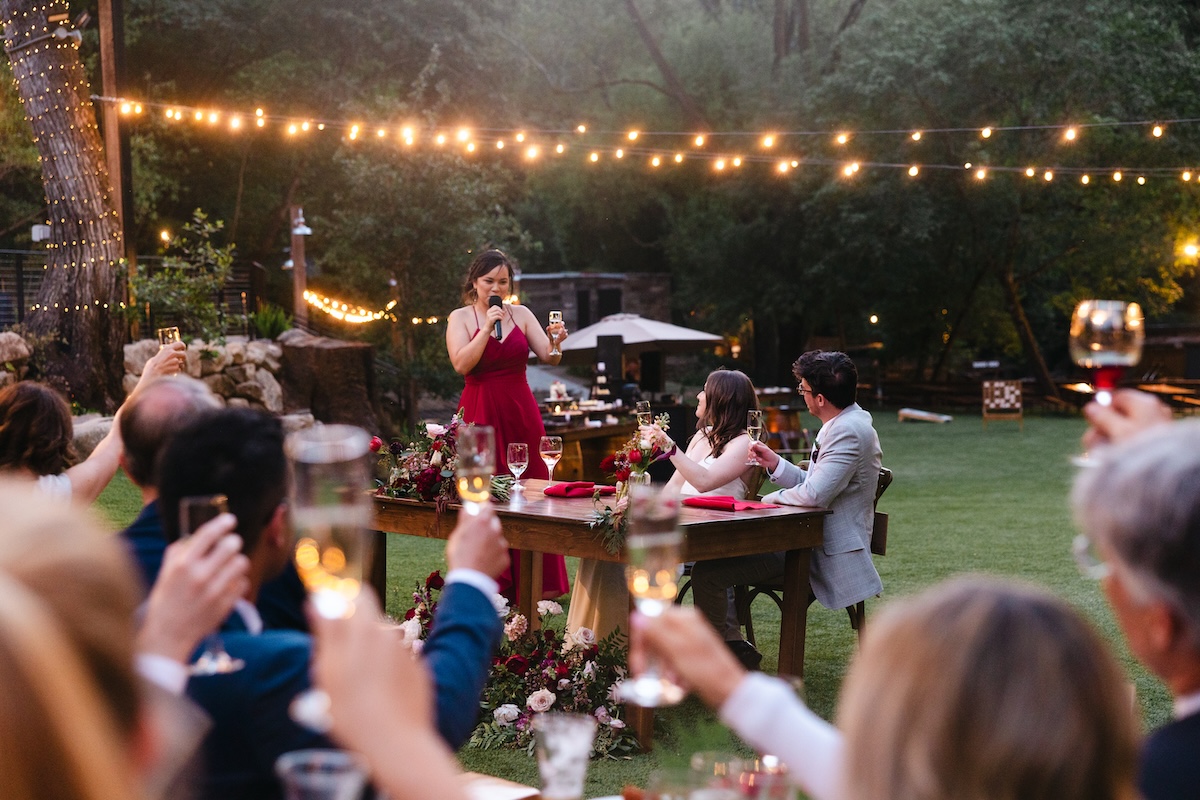 Wedding speeches under twinkling lights at Long Bridge in Saratoga Springs California.