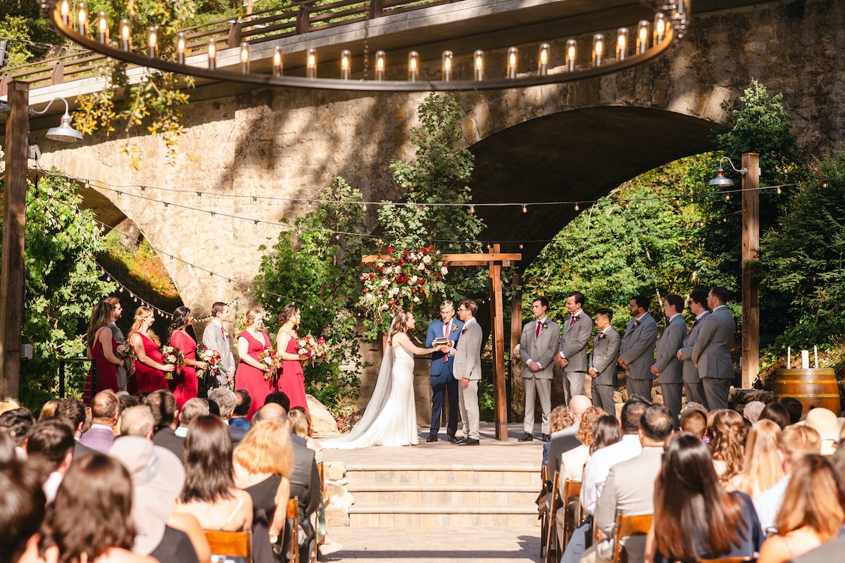 Wedding ceremony at Long Bridge at Saratoga Springs California. Florals by H&J Flowers.