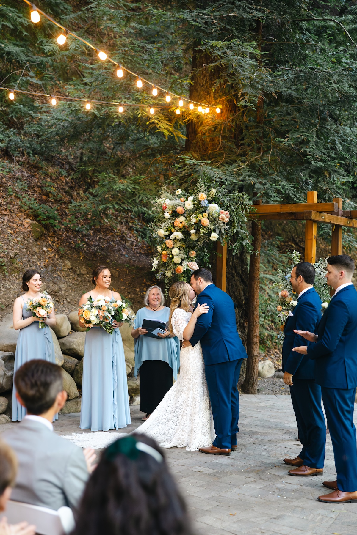 Couple's first kiss at Redwood Grove in Saratoga Springs California. Florals by H&J Flowers.
